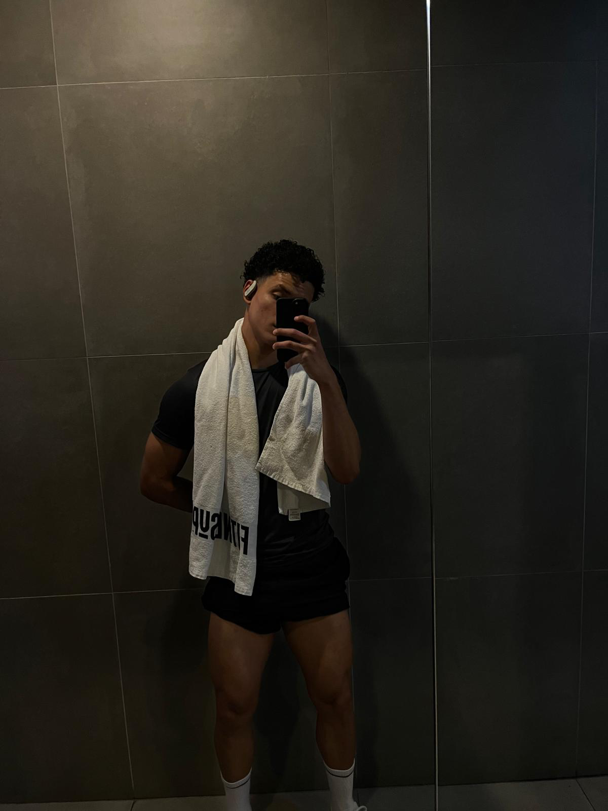 Emiliano Alves após treino, com toalha no pescoço, em foto espelho